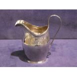 An early 19th century Georgian helmet shape silver Cream Jug, wilt reeded strap handle, bright cut