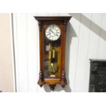 A late 19th century walnut cased Vienna style Wall Clock, cream enamel two part dial in brass ring