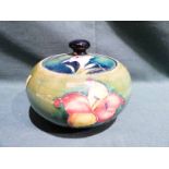 A Walter Moorcroft pottery lidded Jar of squat circular form, tubeline decorated with Fuchsia on a