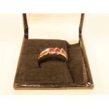 A 9ct gold Art Deco style ruby and diamond ring with two oval cut rubies flanked by chip diamonds