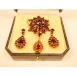 A 9ct gold garnet suite of jewellery including star brooch, pendant necklace and teardrop