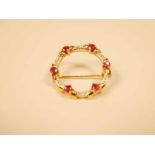 A 9ct gold ruby and chip diamond hoop brooch set with six small rubies 2.5cm diameter, 5g
