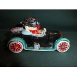 A Carlton Ware hand painted Golly Figure, Driving a Car, trial colourway, 12cm long