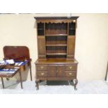 An early 20th century oak Dresser, moulded cornice over three central shelves flanked by inlaid