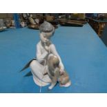 A Lladro model of a Seated Boy and Dog