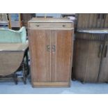 Pratts of Bradford, a 1930s oak Art Deco Tallboy with single drawer above double door cupboard,