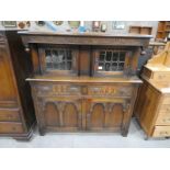 An Old Charm style oak Court Cupboard with glazed cabinets above a pair of frieze drawers and doors,