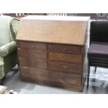 An oak fall front Bureau over 7 Drawers