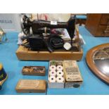 A singer 1950s electric Sewing Machine, reels of Linen Thread and misc Fabric/Zips etc