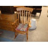 A large farmhouse Rocking Chair with Spar Back and Spindle Sided Arms