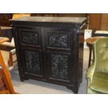 A dark oak two door freestanding Cabinet with carved door panels, 122cm high X 120cm wide X 44cm