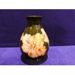 A Walter Moorcroft pottery Vase, teardrop form, tube line decorated with peach Hibiscus on green