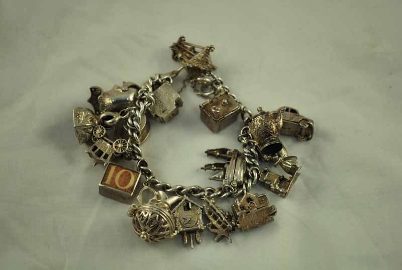 A silver charm Bracelet with 18 silver and white metal charms including a sardonyx seal, 2.8ozt