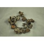 A silver charm Bracelet with 18 silver and white metal charms including a sardonyx seal, 2.8ozt