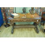An early to mid 20th century oak heavily carved green man Library Table, with single frieze drawer
