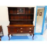 An oak Craft Dresser, the shallow rectangular moulded cornice above a shelved boarded display back