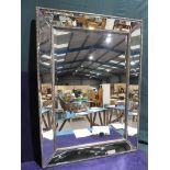 A modern decorative Wall Mirror, central bevelled rectangular glass within a canted mirrored and