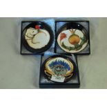 Three boxed Moorcroft Pottery pin dishes in the Sleeping dog, Rosehip and Limited Edition bouquet