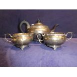 An early 20th century silver three piece Tea Service, circular compressed four footed form, by