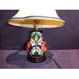 A modern Moorcroft Pottery Table Lamp, tubeline decorated with Poppies and Thistles on a cream