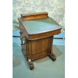 A Victorian walnut Davenport desk with elevated stationary compartment and maple lined well, on four