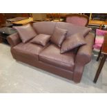 A modern brown leather effect two seater sofa bed with four cushions and mattress topper