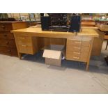 A Dana light ash twin pedestal kneehole desk