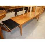 A 1960's teak rectangular extending magazine table with draw leaves at each end and a light ash