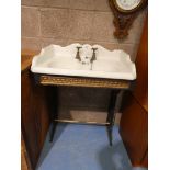 A late 19th / early 20th Century white porcelain bathroom sink inset into a cast iron support