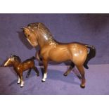 A Beswick pottery brown mare facing left and a foal