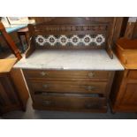 An Edwardian walnut marble top and tiled back wash stand above three drawers