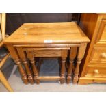 A reproduction oak nest of three occasional tables