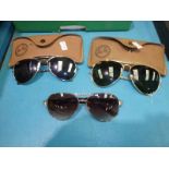 Two pairs of Rayban aviator sunglasses and a pair of Gucci sunglasses