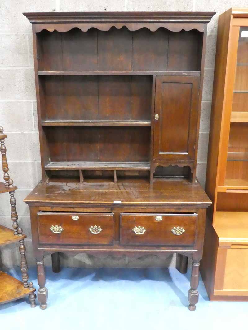 A late19th/early 20th Century oak dresser with two deep drawers and shaped apron on long turned