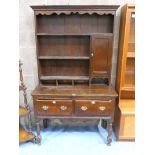 A late19th/early 20th Century oak dresser with two deep drawers and shaped apron on long turned