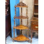 A Victorian walnut four tier whatnot with fretwork top and turned supports