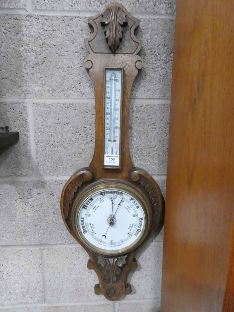 An oak framed aneroid barometer with thermometer banjo style