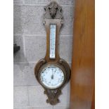 An oak framed aneroid barometer with thermometer banjo style