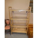 A light oak four tier bookcase with glass shelf inserts