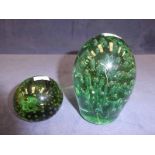 A Victorian green glass dump with bubble inclusions and a similar paper weight