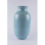 A Chinese celadon glazed vase, baluster form with everted neck decorated in low relief with lotus