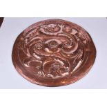 An Arts & Crafts Newlyn style circular copper charger with repoussé decoration in the form of