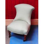 A Victorian flared back nursing chair on turned oak legs to porcelain casters and finished in pale