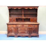 A George III and later oak dresser, the later plate rack with twin cupboards to each side