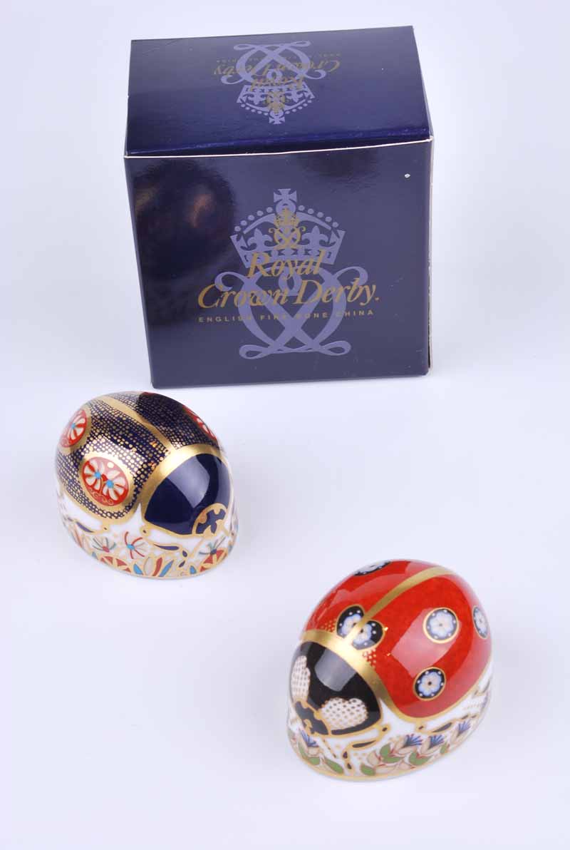 A Royal Crown Derby red ladybird paperweight together with a further blue ladybird example (2)