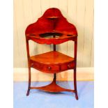 An early 19th Century mahogany corner wash stand of typical form with shaped back wells suitable for