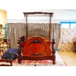 A Victorian mahogany half tester bed; the serpentine footboard with applied cartouche and flanked by