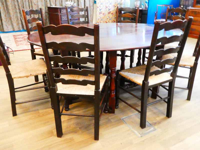 A set of eight oak Lancashire ladderback dining chairs, typical form with rush seat, turned front