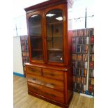 A Victorian flame mahogany two door glazed bookcase on chest of four drawers with square aesthetic