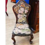 A Victorian nursing chair in rosewood with tapestry cover